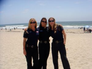 Three women in uniform on a beach