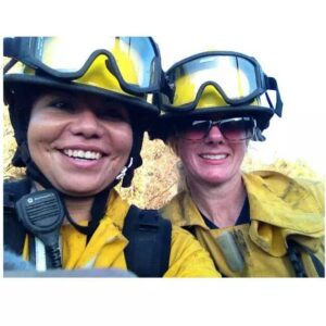 Two firefighters in uniform and wearing helmets